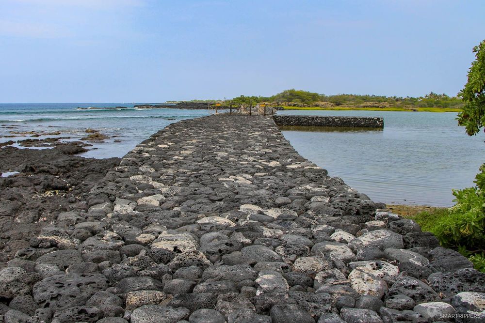 Digue fermant le Kaloko Fishpond, le chenal d'accès se trouve près des barrières.