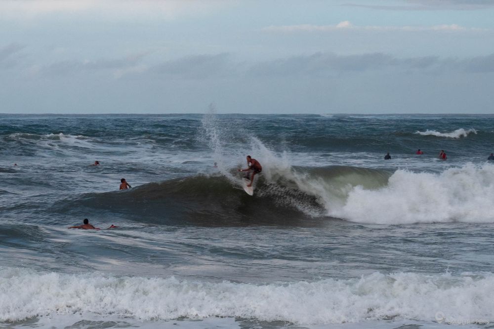 Un surfeur prend la vague à Lower Pā'ia Beach à Maui